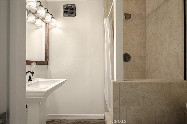 bathroom featuring wood-type flooring, sink, and a shower with shower curtain