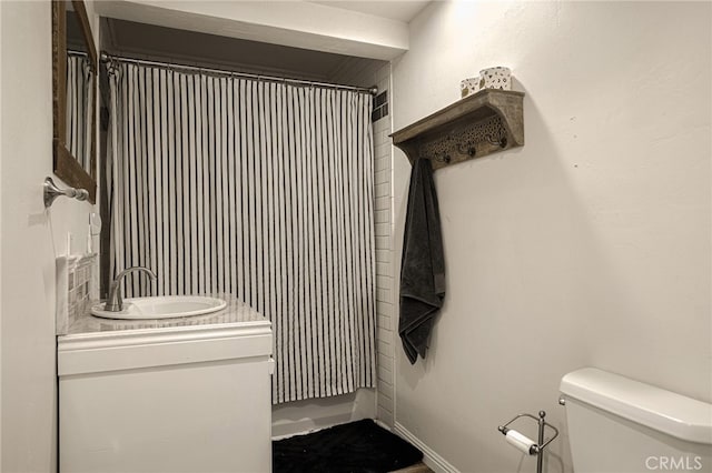 bathroom featuring a shower with curtain, vanity, and toilet