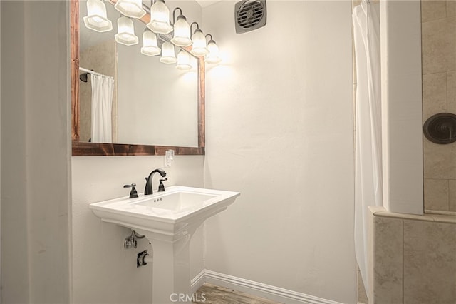 bathroom with hardwood / wood-style floors and curtained shower