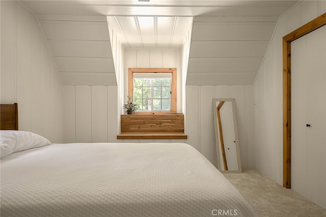 bedroom with carpet, wooden walls, and a closet