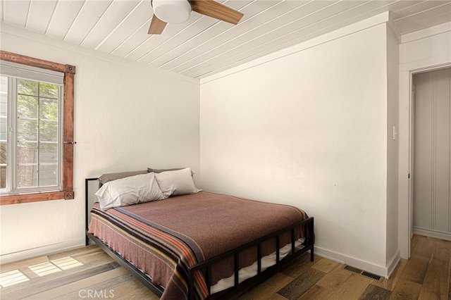 bedroom with crown molding, ceiling fan, and hardwood / wood-style flooring