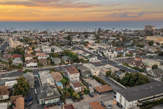 aerial view at dusk featuring a water view