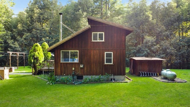 view of side of home featuring a lawn, a deck, and a storage unit