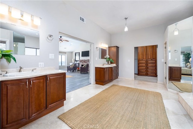 bathroom featuring tile patterned flooring, ceiling fan, vanity, and a brick fireplace