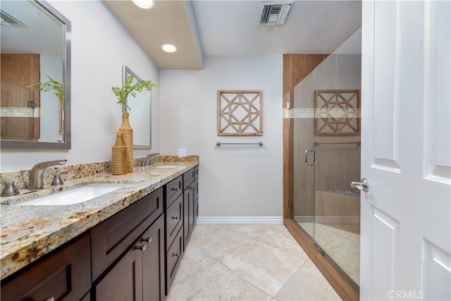 bathroom with vanity and a shower with door