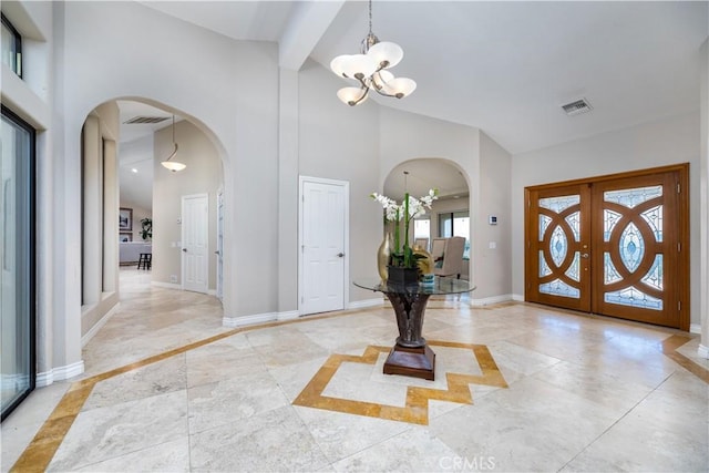 foyer entrance with french doors, a high ceiling, and an inviting chandelier