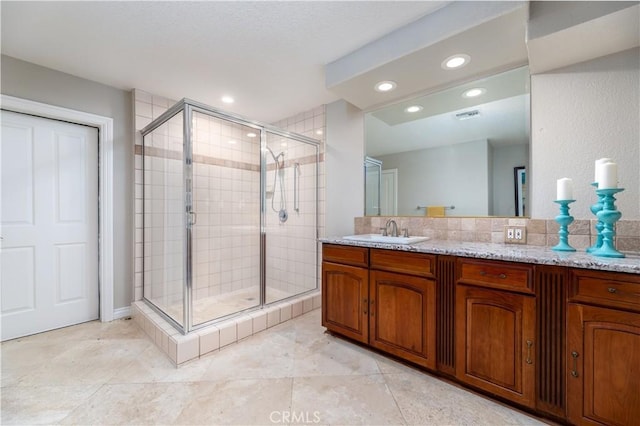 bathroom with a shower with door and vanity