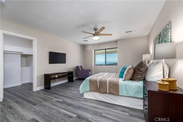 bedroom with wood-type flooring, a textured ceiling, and ceiling fan