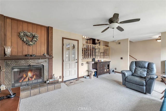 living room with ceiling fan, a fireplace, and light carpet