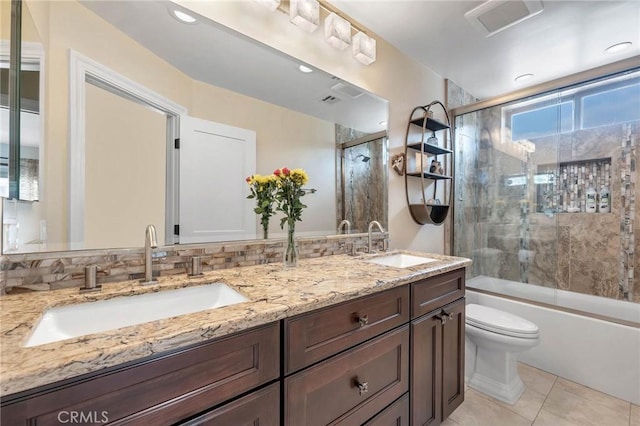 full bathroom featuring vanity, bath / shower combo with glass door, tile patterned flooring, toilet, and tasteful backsplash