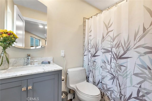 bathroom featuring vanity, toilet, and walk in shower