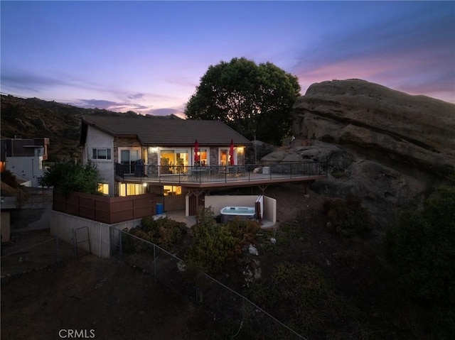 back house at dusk with a mountain view and a balcony