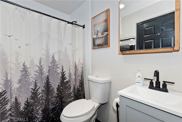 bathroom with curtained shower, vanity, and toilet