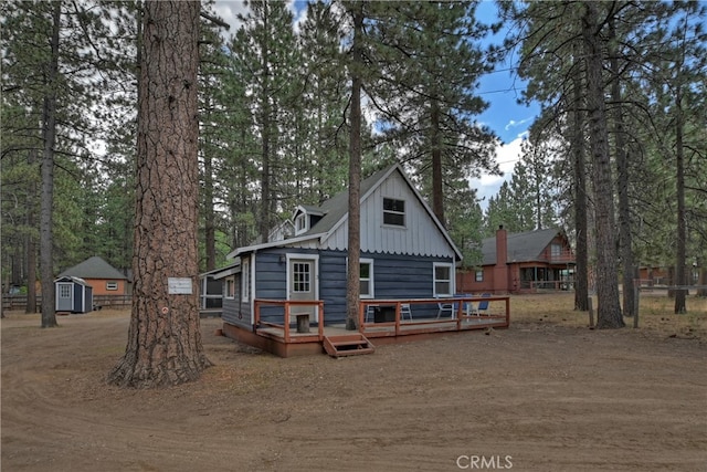 rear view of house with an outbuilding and a deck