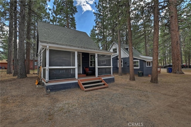 rear view of house featuring a sunroom