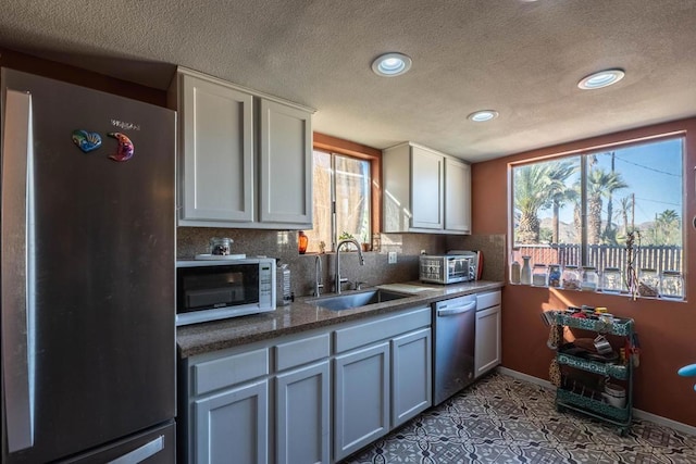 kitchen with sink, stainless steel appliances, white cabinetry, and light tile patterned flooring