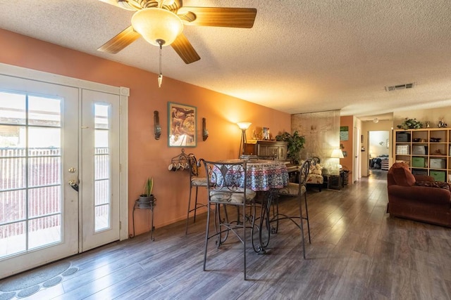 dining area featuring a textured ceiling, ceiling fan, and dark hardwood / wood-style flooring