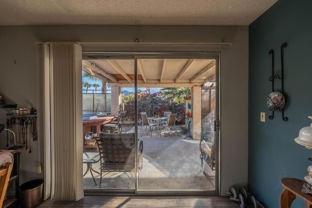 doorway to outside featuring a textured ceiling