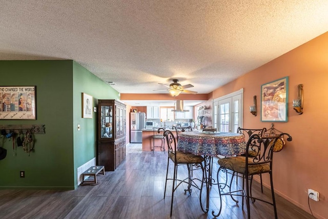 dining room featuring a textured ceiling, ceiling fan, and dark hardwood / wood-style floors