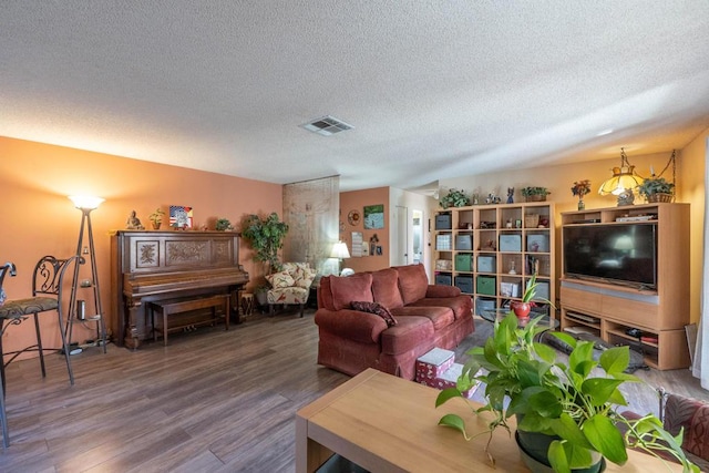 living room with a textured ceiling and wood-type flooring