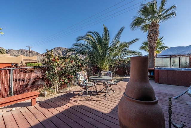 deck with a hot tub and a mountain view