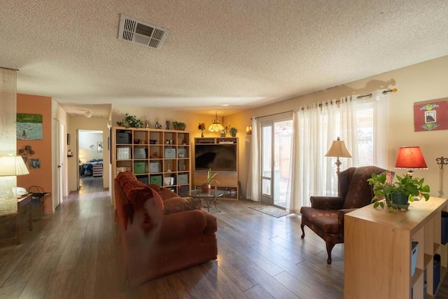 living room with a textured ceiling and wood-type flooring