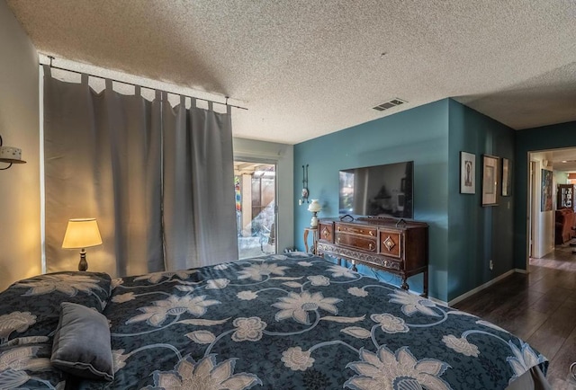 bedroom with a textured ceiling and dark hardwood / wood-style floors