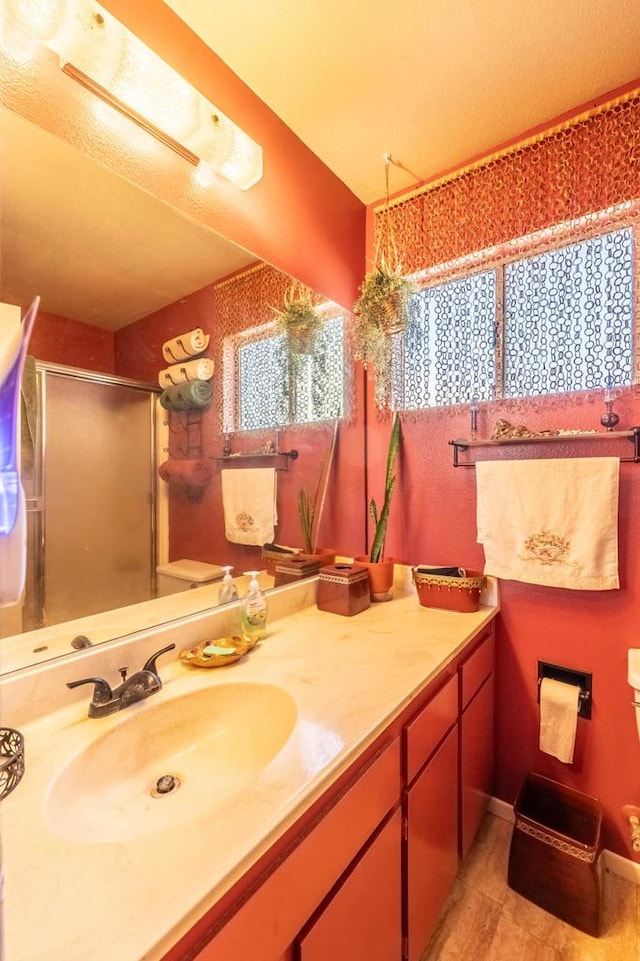 bathroom with a shower with door and vanity