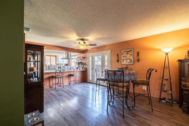 dining room featuring a textured ceiling, ceiling fan, and dark hardwood / wood-style floors