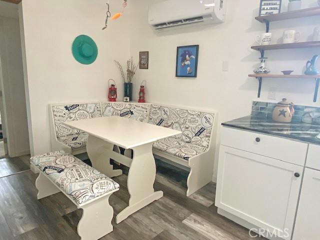 61974 Terrace Dr, Joshua Tree, CA 92252 - dining space featuring breakfast area, a wall unit AC, and wood finished floors