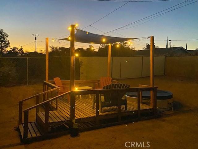 61974 Terrace Dr, Joshua Tree, CA 92252 - patio terrace at dusk featuring a wooden deck, a fenced backyard, and outdoor dining space