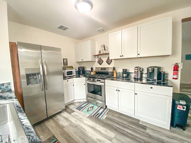 kitchen featuring light hardwood / wood-style flooring, white cabinets, and appliances with stainless steel finishes