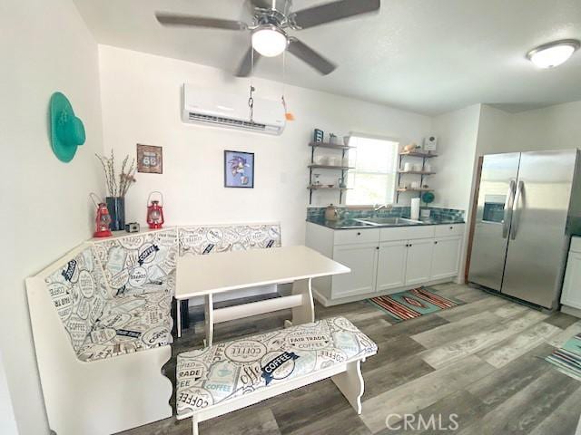 61974 Terrace Dr, Joshua Tree, CA 92252 - kitchen with stainless steel refrigerator with ice dispenser, a wall mounted air conditioner, light wood-type flooring, open shelves, and a ceiling fan