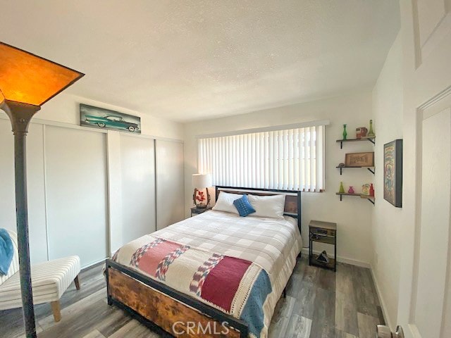 bedroom with dark hardwood / wood-style floors and a closet