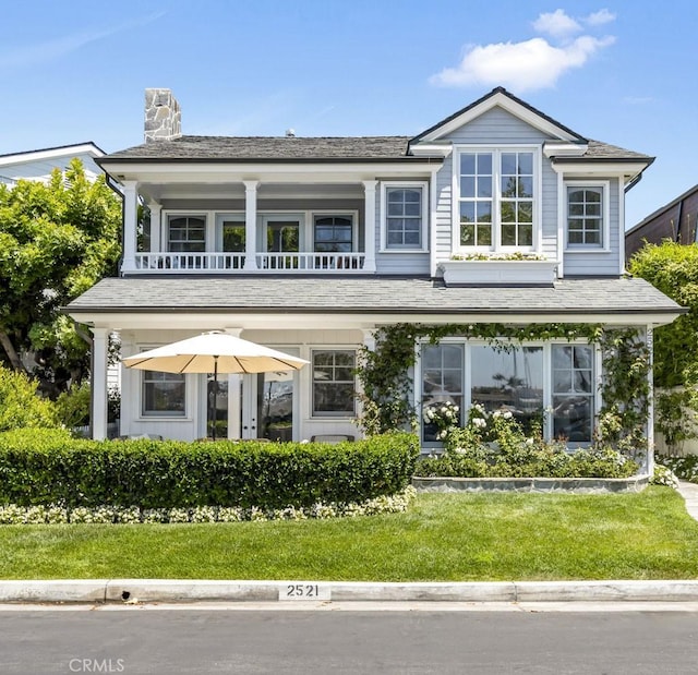 exterior space with a balcony and a front lawn