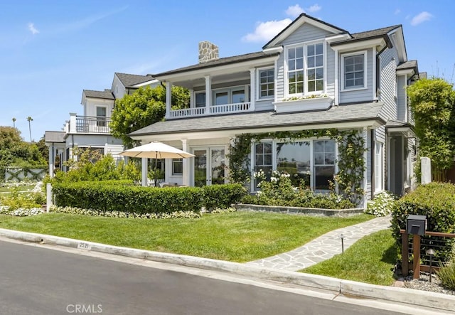 view of front of property with a balcony and a front yard