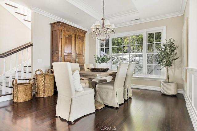 dining room with a notable chandelier, a raised ceiling, ornamental molding, and dark wood-type flooring