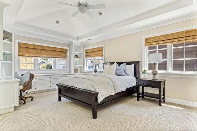 carpeted bedroom with a tray ceiling and ceiling fan