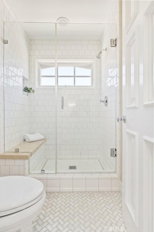 bathroom featuring an enclosed shower and toilet