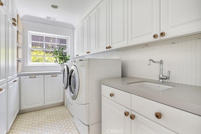 washroom with cabinets, independent washer and dryer, crown molding, and sink