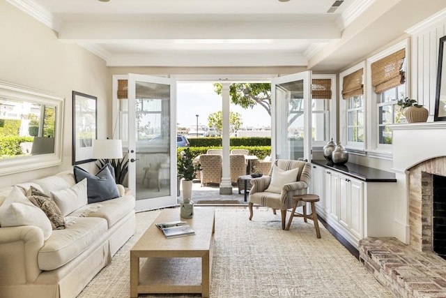 sunroom with beam ceiling and a brick fireplace