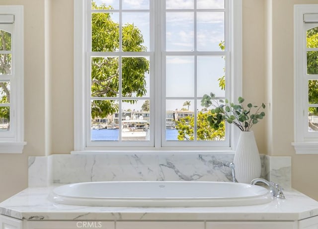 bathroom featuring a tub to relax in and a wealth of natural light