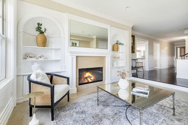 living room with built in features and ornamental molding