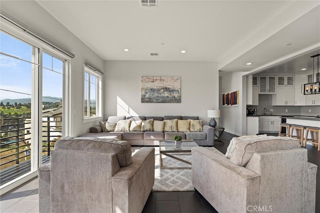 living room featuring sink and light tile patterned floors