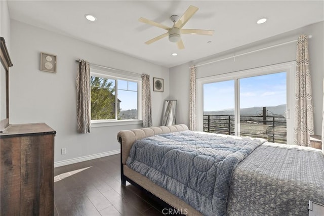 bedroom featuring a mountain view, access to outside, dark hardwood / wood-style floors, and ceiling fan