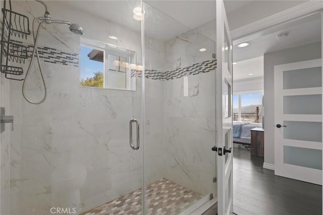 bathroom with a shower with door and wood-type flooring