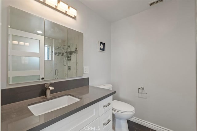 bathroom featuring vanity, toilet, and walk in shower