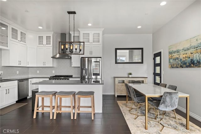 kitchen featuring tasteful backsplash, hanging light fixtures, white cabinets, and appliances with stainless steel finishes