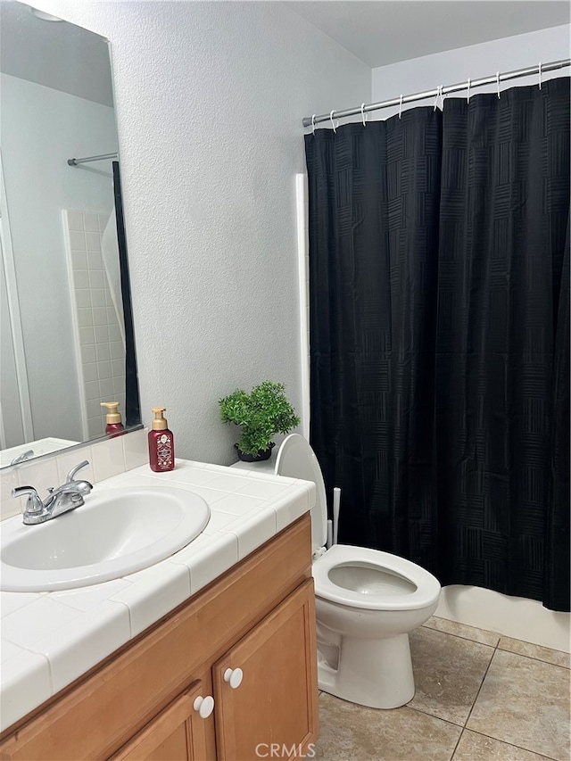 bathroom with walk in shower, vanity, tile patterned flooring, and toilet