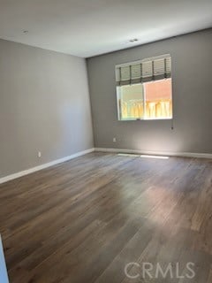 empty room with dark hardwood / wood-style flooring